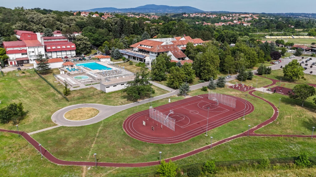 Pogled iz vazduha na kompleks Selters banje u Mladenovcu sa spoljnim bazenom, sportskim terenima i zelenim okruženjem.